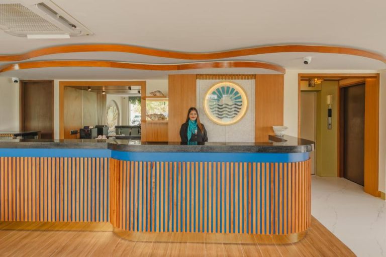 Recepción principal del UMET Seaview Hotel con diseño moderno en madera y azul con logo iluminado