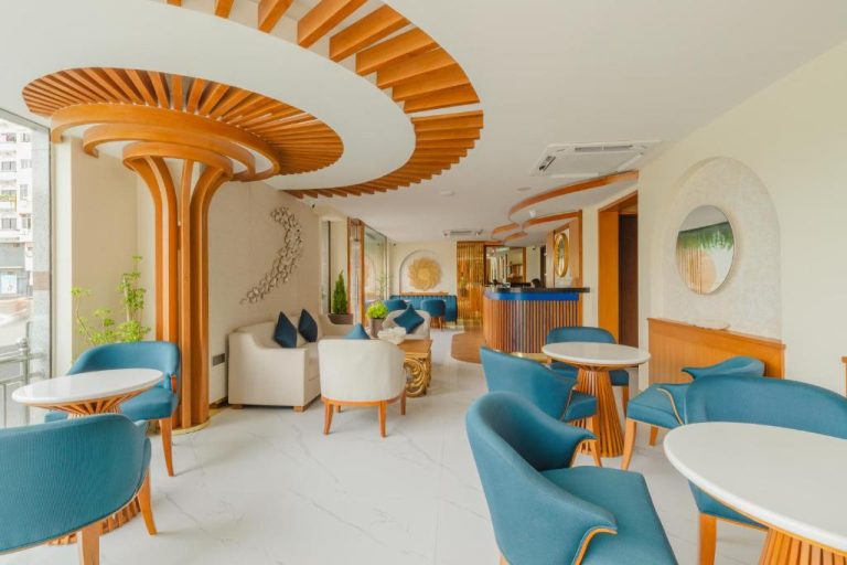 Elegante lobby del UMET Seaview Hotel con sillones azules y decoración en madera con techo espiral