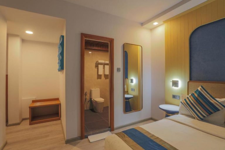 Habitación con baño en suite, espejo de cuerpo entero y cama doble en UMET Seaview Hotel
