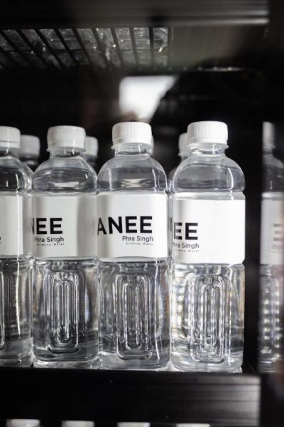 Botellas de agua mineral NANEE Phra Singh refrigeradas en minibar del hotel
