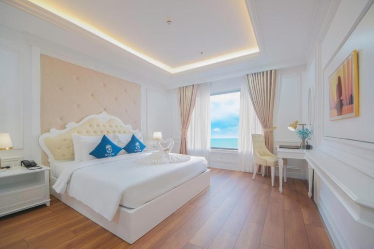 Habitación doble de lujo con vista al mar en Sea Soul Hotel, cama king y decoración elegante en blanco
