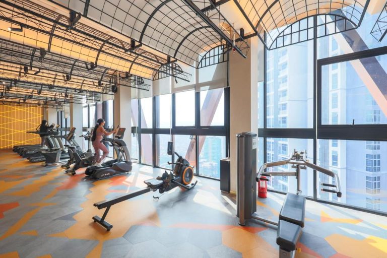 Gimnasio moderno con equipamiento fitness y vistas panorámicas a la ciudad en Scarletz Suites KLCC