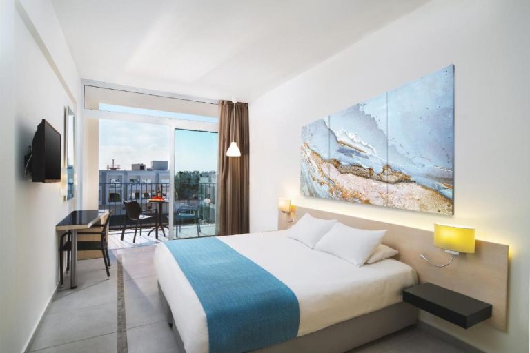 Habitación doble moderna con balcón y vistas al exterior en el Mayfair Hotel