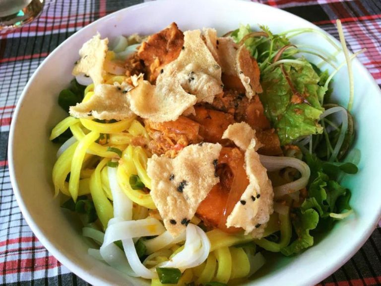 Plato típico vietnamita Cao Lau con fideos amarillos, vegetales frescos y crackers de arroz en Bonsai Villa Hoi An