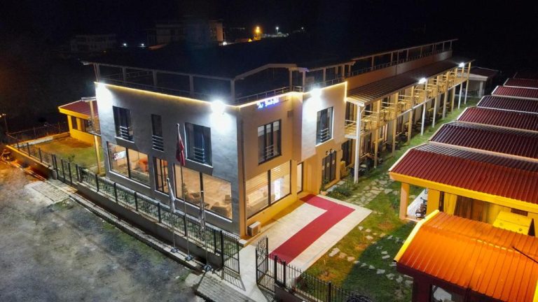Vista nocturna de la fachada iluminada del Yalıköy Deniz Otel Istanbul con bungalows exteriores