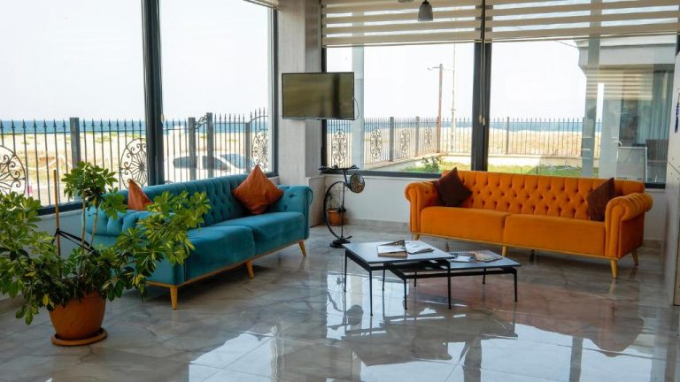 Salón con sofás azul y naranja y vistas al mar en Yalıköy Deniz Otel Istanbul