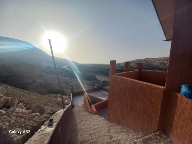 Terraza exterior con vistas panorámicas al paisaje desértico y montañas del BananaHouse al atardecer