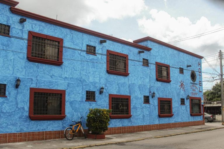 Fachada exterior azul con ventanas enrejadas del Hotel La Casona Real en México