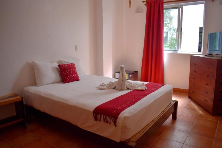 Habitación doble con cama matrimonial y decoración en rojo del Zihil Ha Hotel