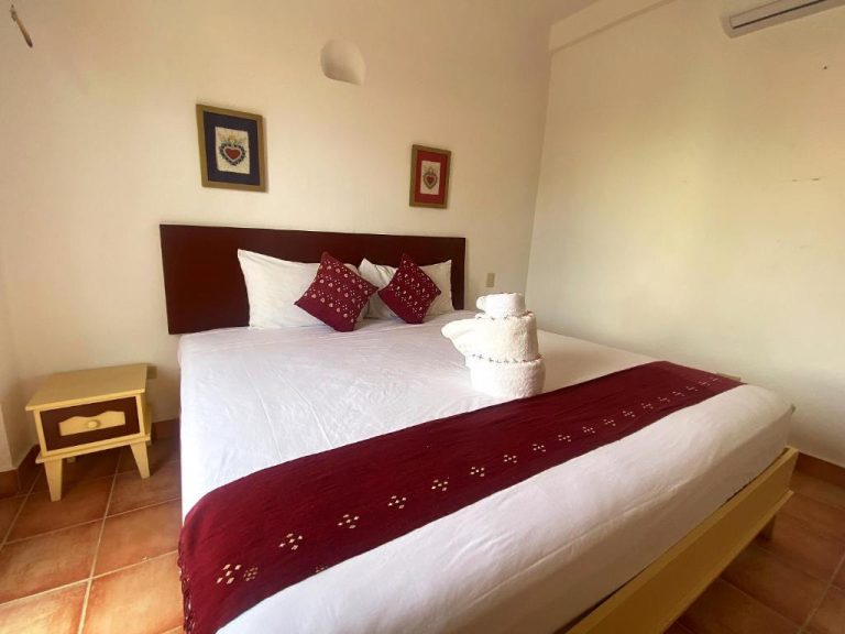 Habitación doble con cama matrimonial y decoración en rojo del Zihil Ha Hotel