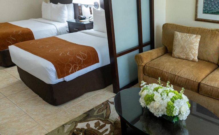 Suite doble con dos camas y zona de estar con sofá en Comfort Suites Paradise Island