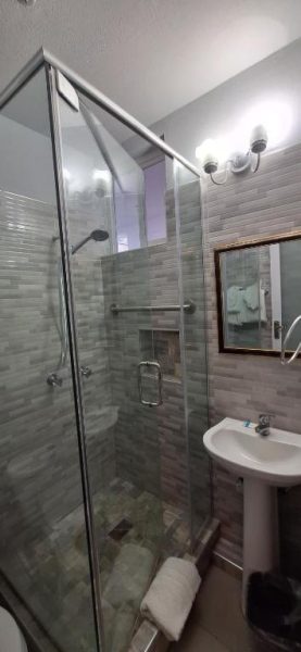 Baño moderno con ducha de cristal y lavabo en Beach Studio 24 at Sandcastles