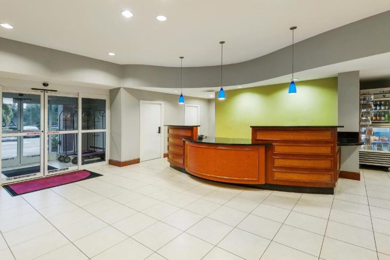Recepción y lobby del Residence Inn Orlando Airport con mostrador de madera y luces azules