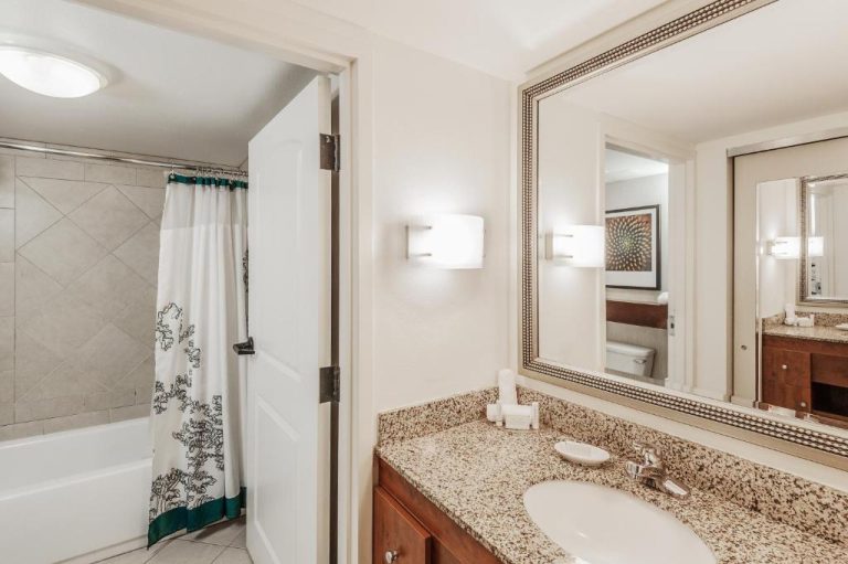 Baño completo con bañera y ducha del Residence Inn Orlando Airport con encimera de mármol