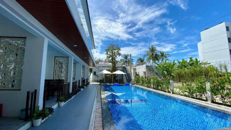 Piscina exterior con sombrillas y jardín tropical del West Life Bungalow Phu Quoc