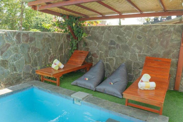 Piscina privada con tumbonas de madera y pufs en Amalla Lodge Penida by Omanera