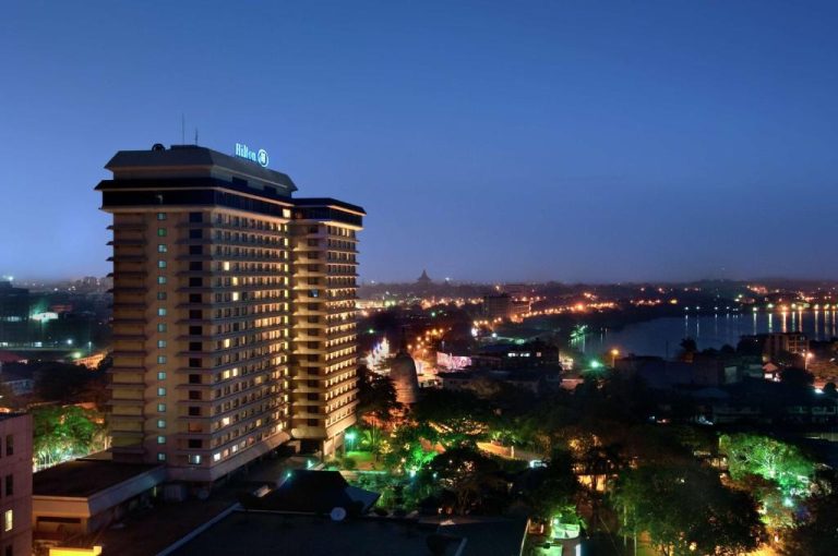 Vista nocturna del Hilton Colombo Hotel con panorámica de la ciudad y el lago iluminados