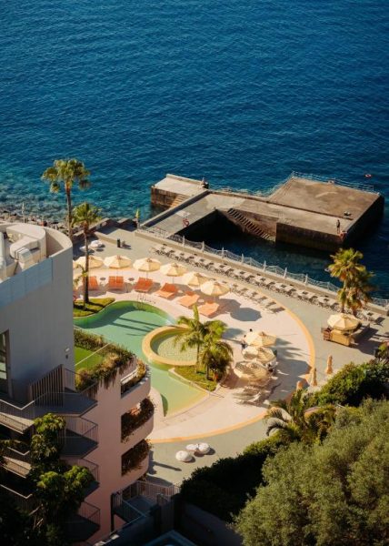 Piscina exterior con tumbonas y sombrillas del hotel Next by Savoy Signature con vistas al mar