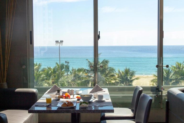 Restaurante del M Hotel Danang con mesa de desayuno y vistas panorámicas al mar y playa