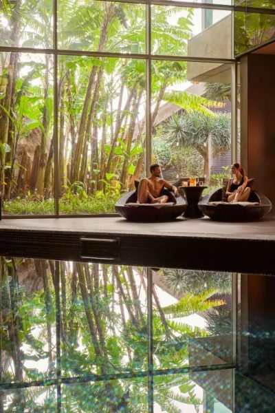 Zona de relax con vistas a jardín tropical junto a la piscina interior del Saccharum Resort and Spa Savoy
