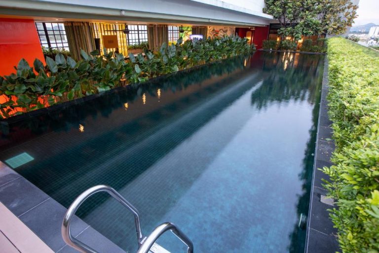 Piscina interior con plantas tropicales y vistas panorámicas en The Upper House Batu Kawan