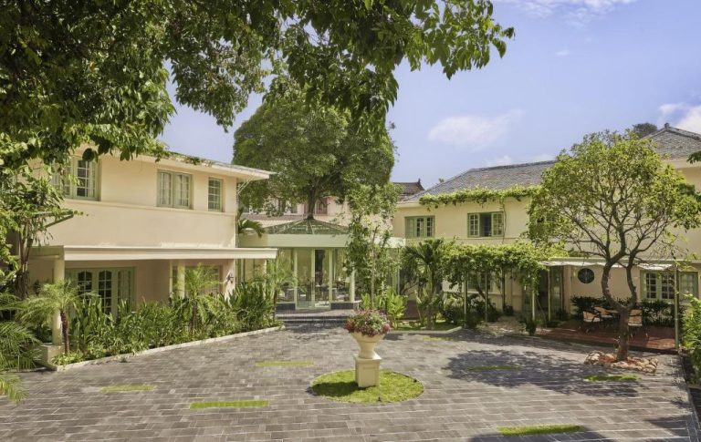 Jardín exterior con fuente y vegetación tropical del President Maison Signature by M Village en Vietnam