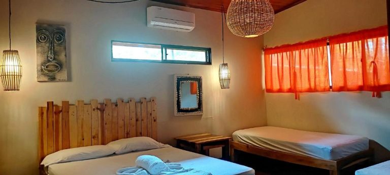 Habitación triple con cabecero de madera reciclada y decoración tropical en El Belga Loco