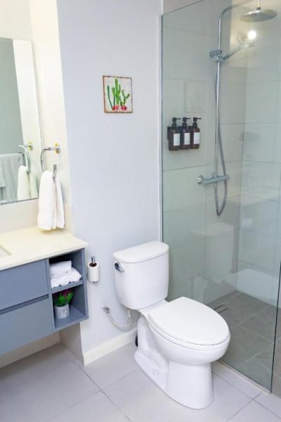 Baño moderno con ducha de lluvia y cabina de cristal en Premium Studio with Pool View