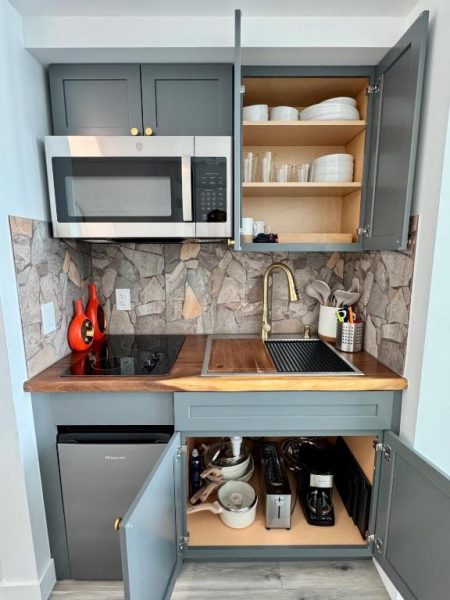 Kitchenette completamente equipada con microondas, fregadero y encimera de madera en Balcony Ocean View