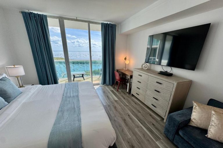 Habitación con cama doble, televisión y balcón con vistas al mar y marina en Balcony Ocean View