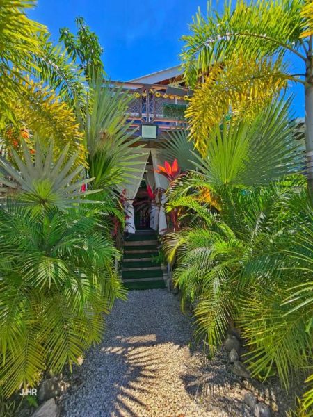 Entrada principal rodeada de jardín tropical exuberante en BellaVista Suites By Villas Verdes en Samara Beach