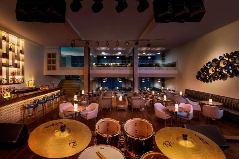 Bar con escenario de música en vivo y zona lounge del hotel Le Meridien Goa Calangute
