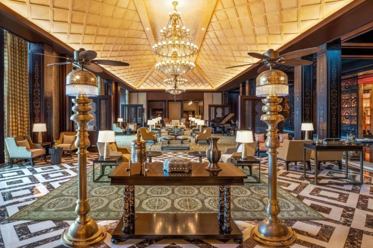 Lujoso lobby del The St. Regis Cairo con lámparas doradas, araña de cristal y elegante decoración árabe