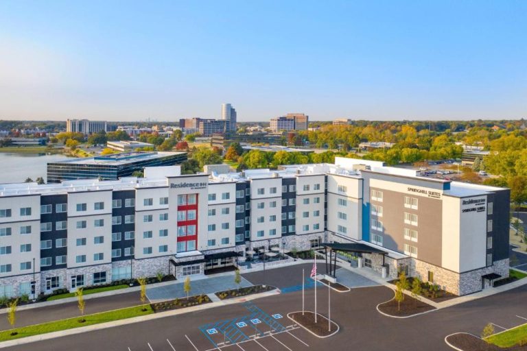 Vista aérea del exterior del SpringHill Suites by Marriott Indianapolis Keystone con aparcamiento y entorno urbano