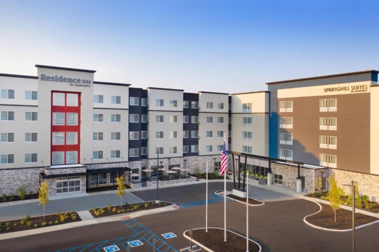 Fachada exterior del SpringHill Suites by Marriott Indianapolis Keystone con aparcamiento y banderas