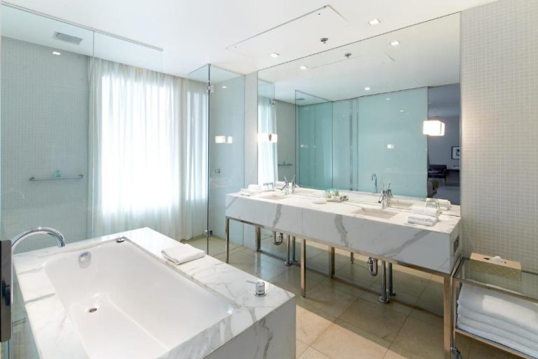 Baño de lujo con bañera exenta de mármol y doble lavabo en Establishment Hotel