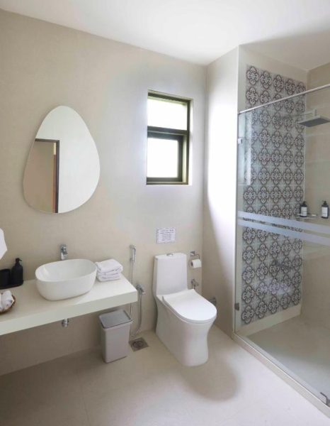 Baño moderno con ducha de azulejos decorativos en Radha House Siolim, hotel boutique en Goa