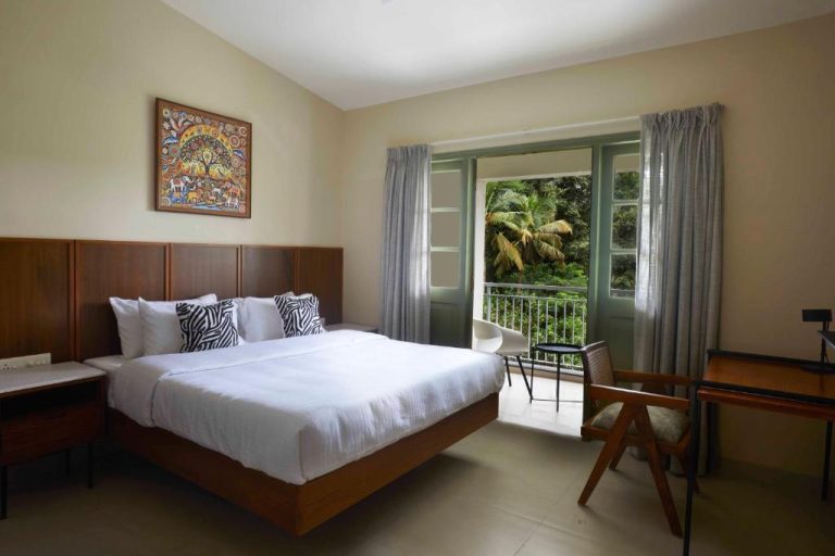 Habitación doble con cama king y balcón con vistas a la naturaleza en Radha House Siolim Boutique Hotel