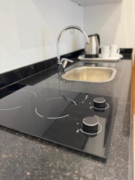 Cocina compacta con vitrocerámica de dos fuegos y fregadero integrado en Zones Residence Maadi