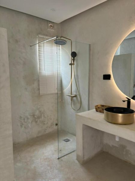 Baño moderno con ducha de lluvia y lavabo dorado en Hotel Le Saint Tropez