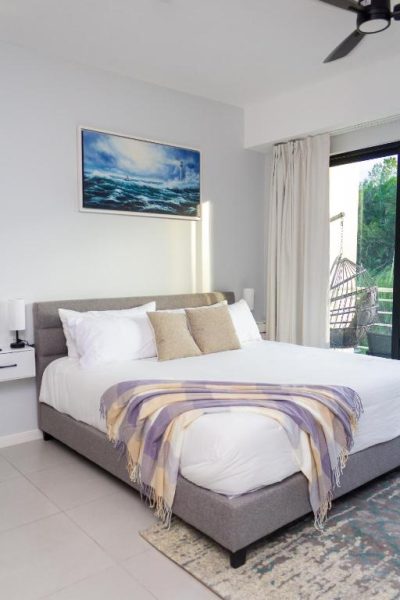 Habitación con cama doble, decoración moderna y balcón con vista a la piscina en Premium Studio