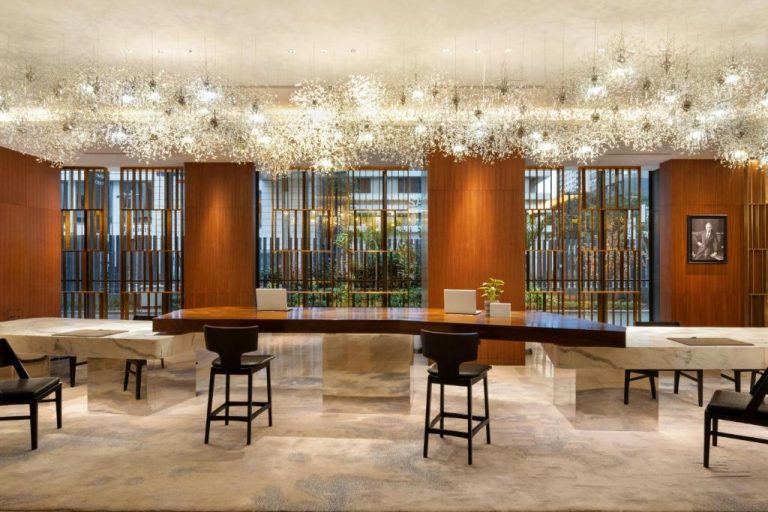 Lujoso lobby del JW Marriott Hotel Nairobi con recepción de madera y araña de cristal