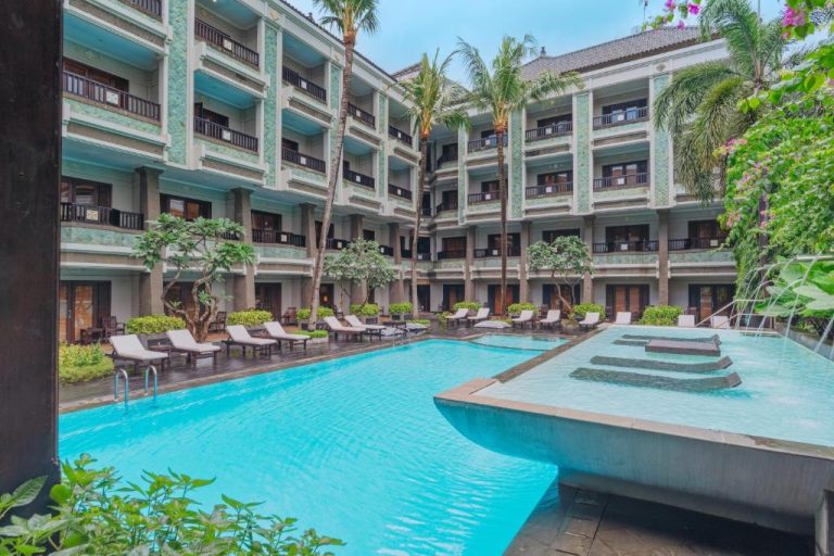 Piscina exterior con tumbonas y jardín tropical del The Vira Bali Boutique Hotel & Suite en Bali