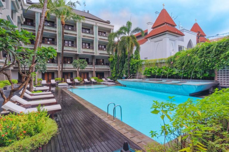 Piscina exterior con tumbonas y jardín tropical del The Vira Bali Boutique Hotel & Suite en Bali
