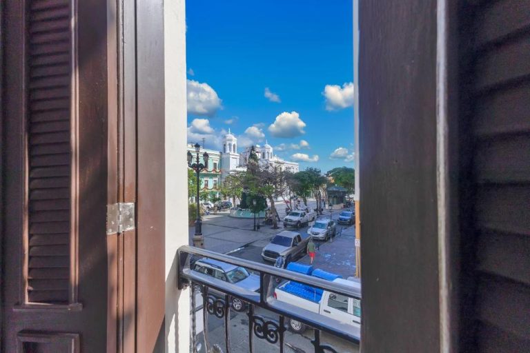 Vista desde el balcón del Armas Hotel hacia la plaza colonial con edificios históricos y cielo azul