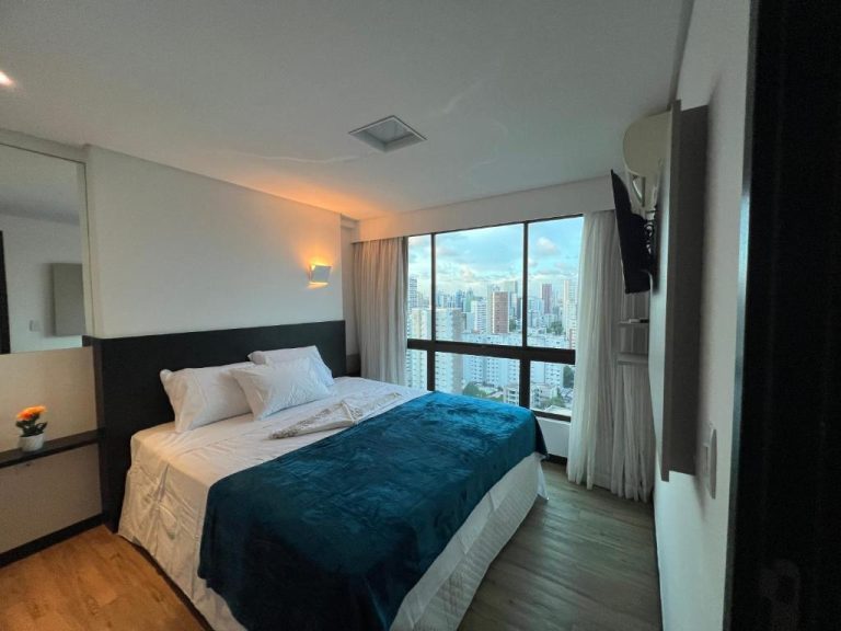 Habitación doble con cama y vista panorámica a la ciudad en el Flat Ramad