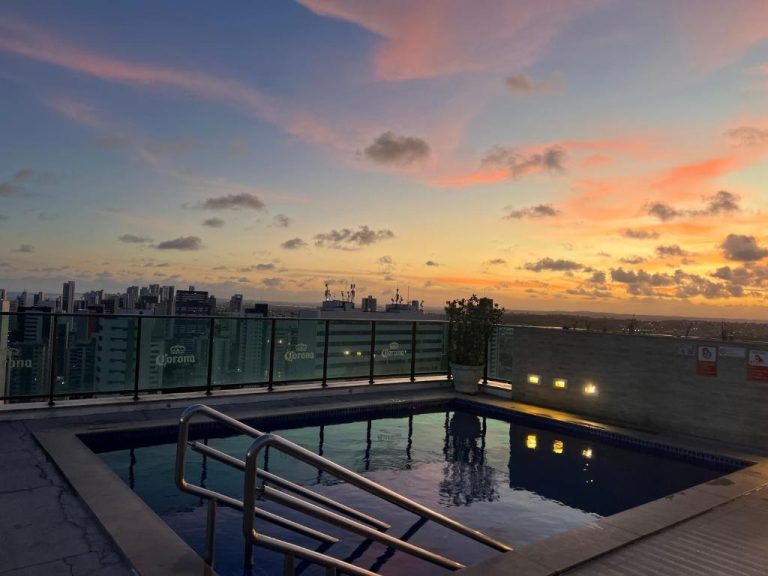 Piscina en la azotea del Flat Ramad con vistas panorámicas de la ciudad al atardecer