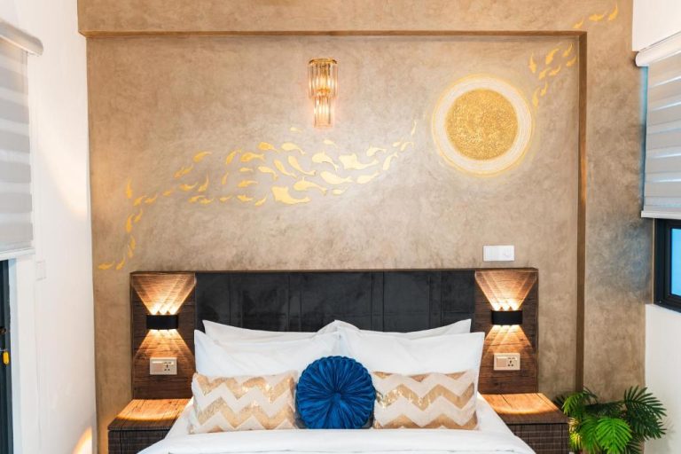 Habitación de lujo con mural dorado de peces y cama king en Aina Residency Beachfront Hotel
