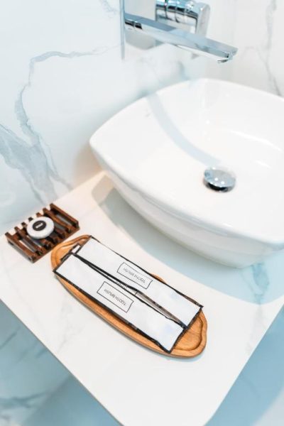 Amenities de baño con cepillos de dientes y jabón en el Aina Residency Beachfront Hotel