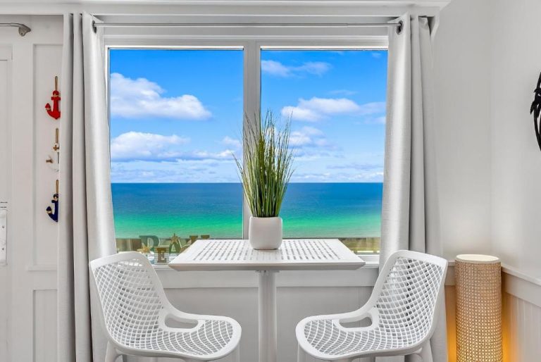 Habitación con mesa blanca y vista panorámica al mar turquesa en Pinnacle Port, Panama City Beach